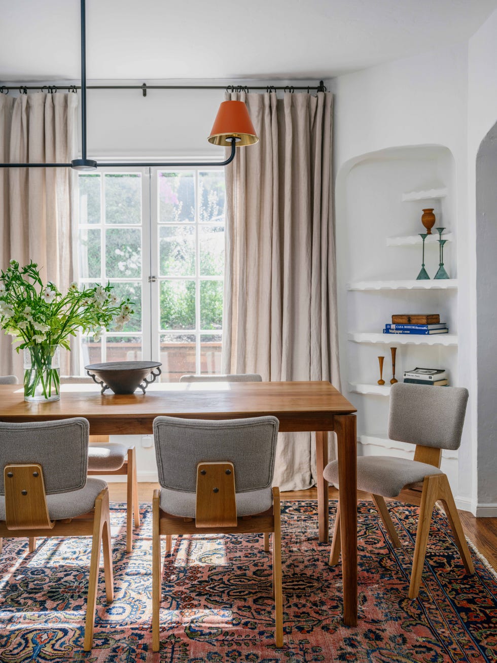 a wooden dining table over a patterned carpet