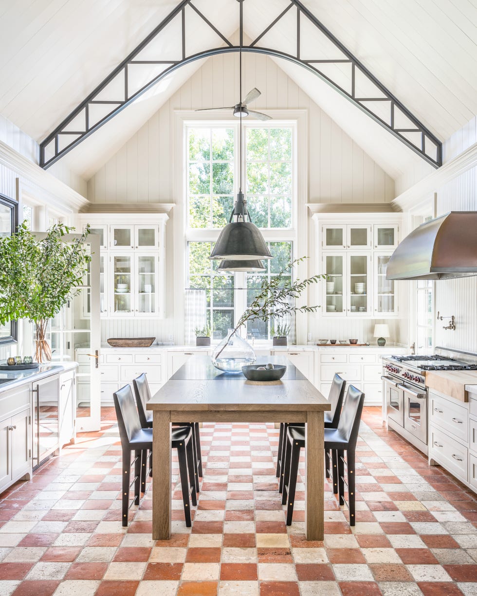 modern kitchen with a large table and chairs featuring ample natural light and stylish decor